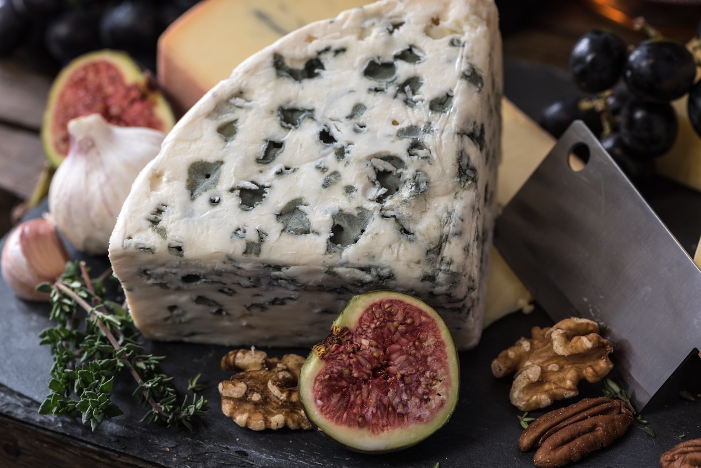 Three approachable French cheeses served with bread and fruit on a simple table.